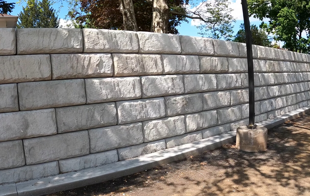 Large concrete block retaining wall along a residential sidewalk in Laredo, TX